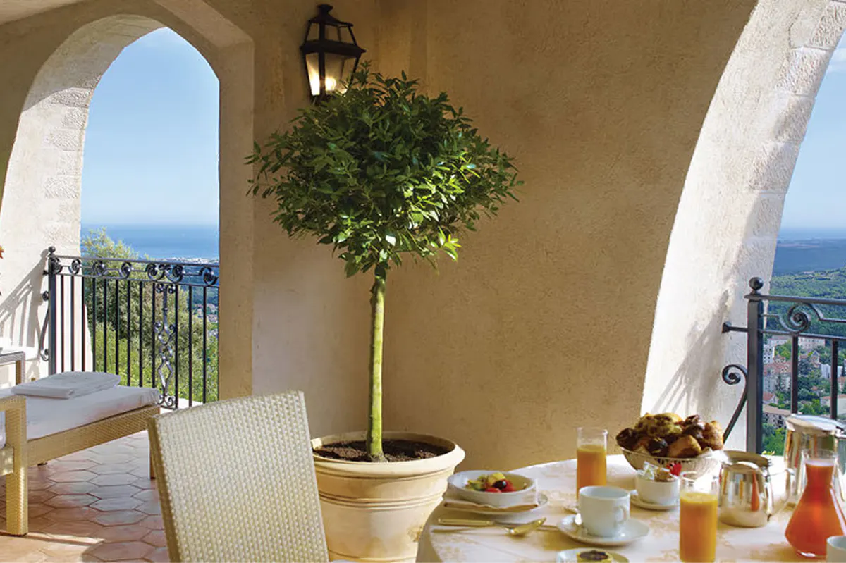 Arched balcony with sea views, lounge chair, and topiary planting
