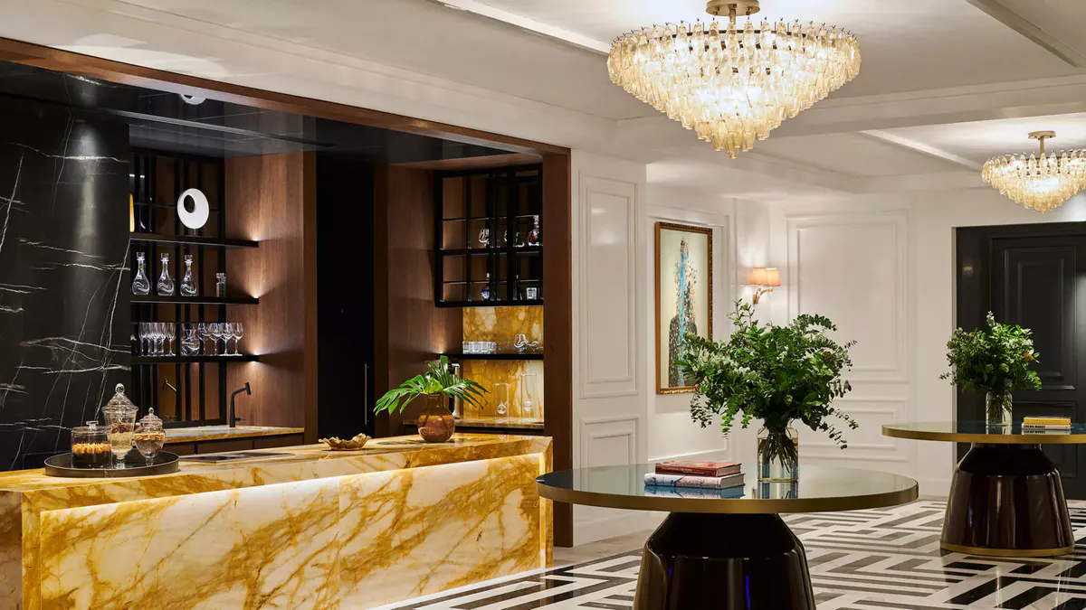 The lobby reception area with gold marble countertop, crystal chandelier, and white finishes