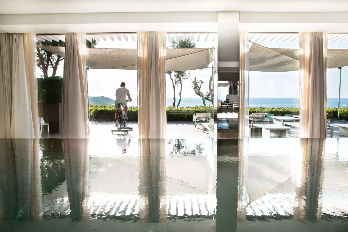 Light-filled spa hallway with white walls and sea views