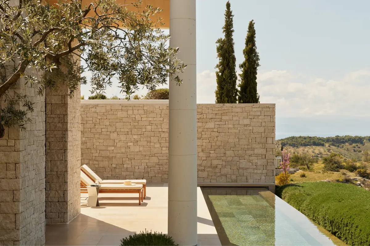 Sheltered courtyard with lounging area overlooking distant blue water