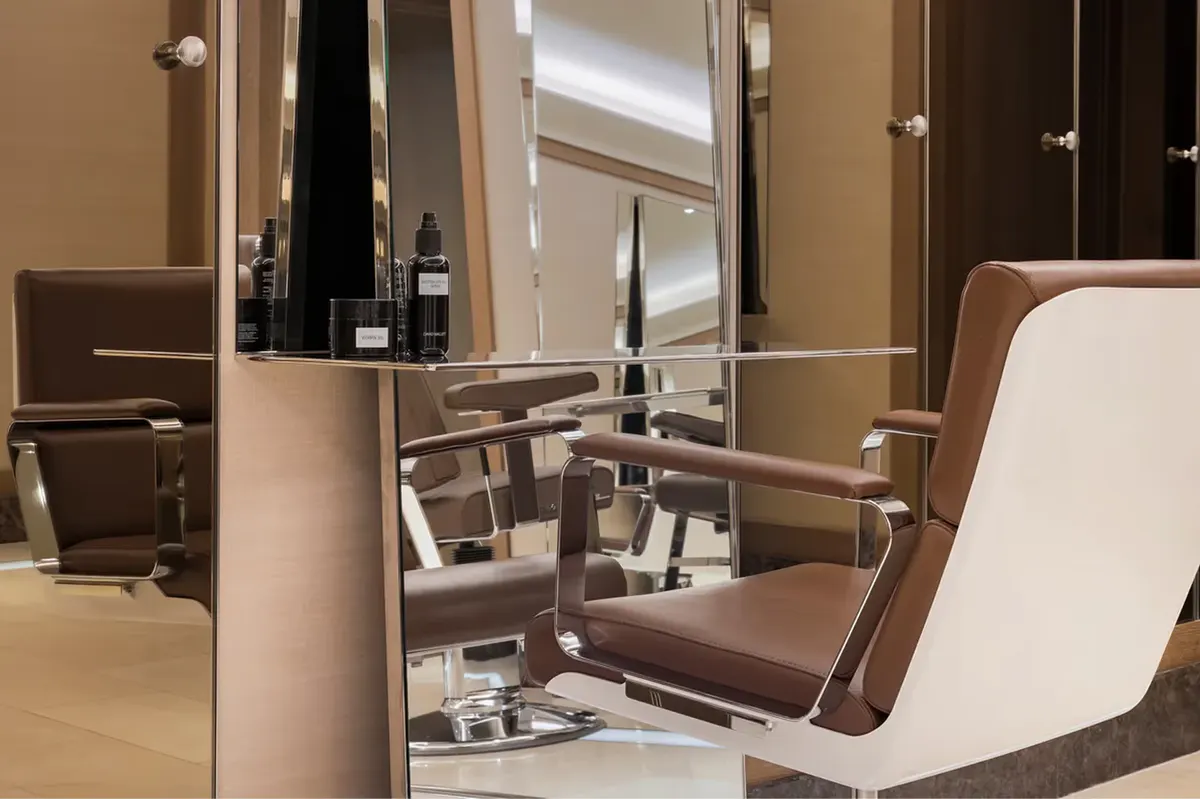A salon styling station with mirrors and professional treatment chair