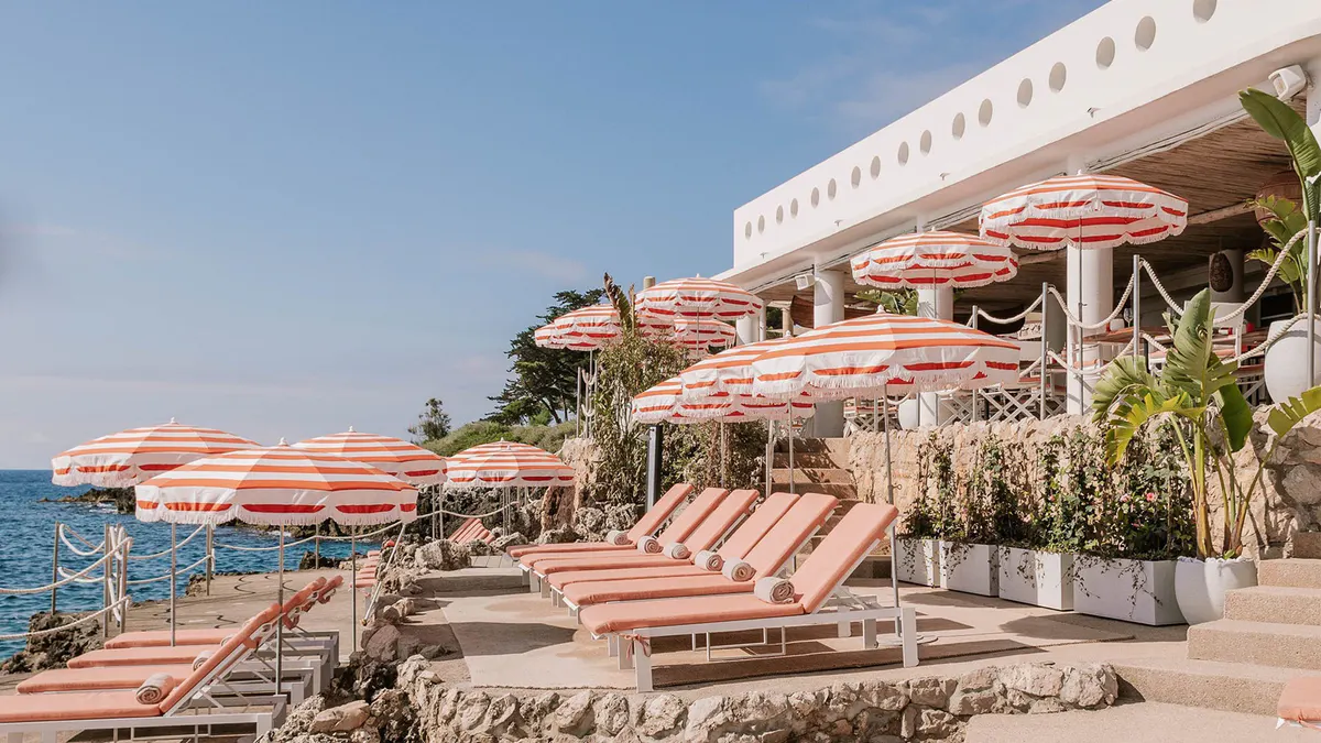 Waterfront terraces with orange umbrellas and lounge seating
