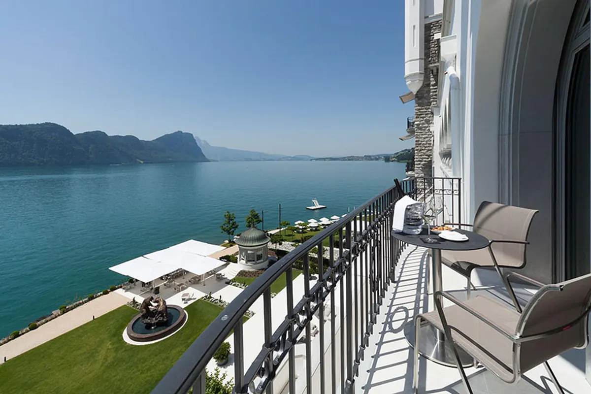 Terraced lakeside balcony with dining tables overlooking turquoise water