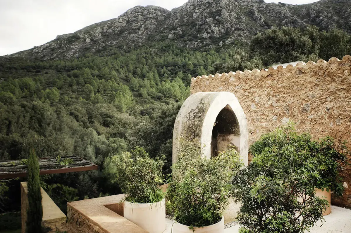 Contemporary domed structure with stone construction overlooking green estate grounds and distant mountains