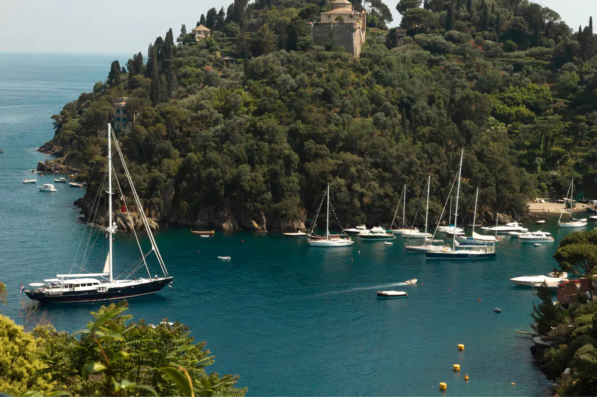 Aerial view of a secluded cove with sailboats and white beach club structures