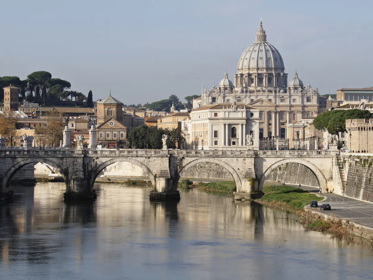 St. Peter’s Basilica and Tiber bridges at dusk from across the water
