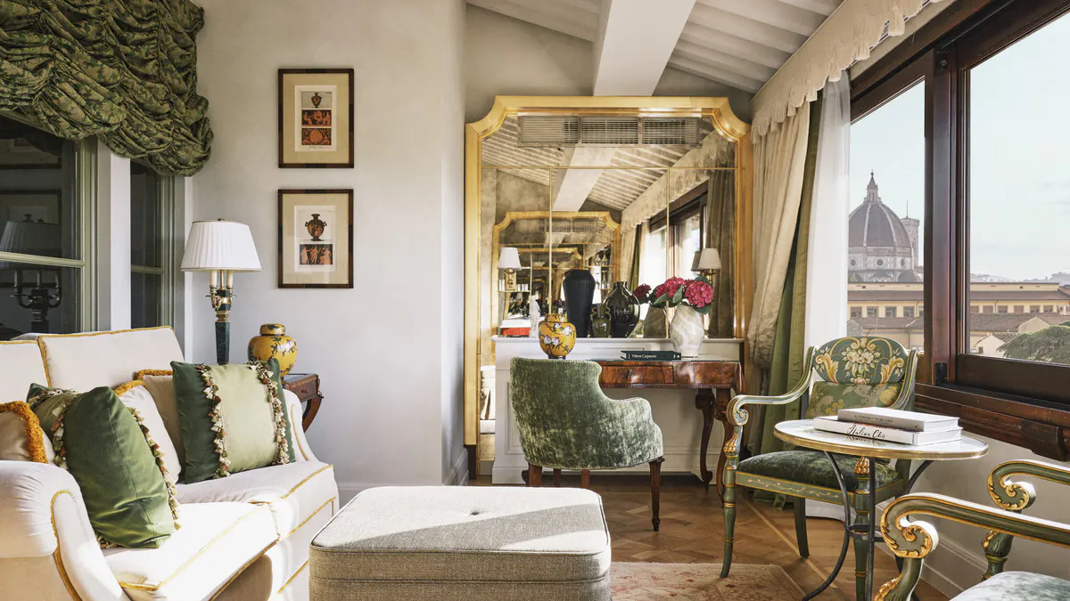 Suite interior with cream walls, gallery views of the Duomo through tall windows, and classical furnishings