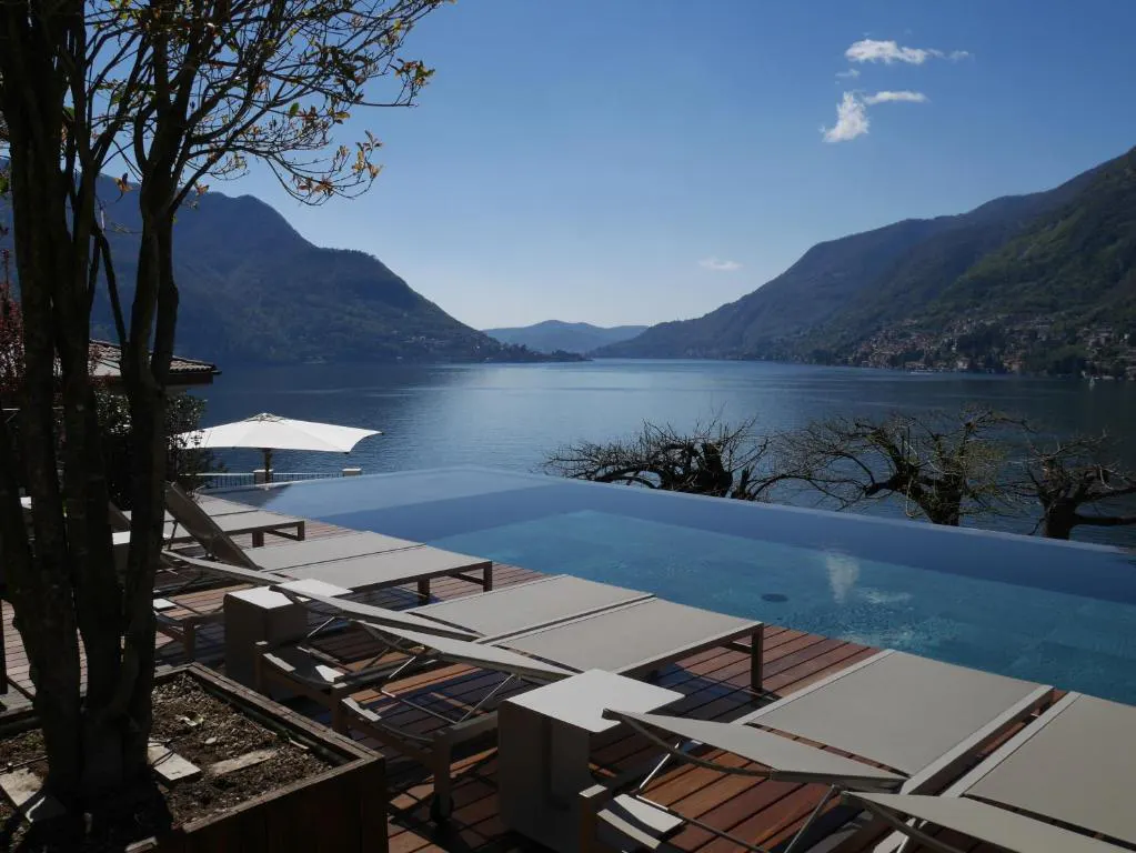 Infinity pool with lounge seating and lake vista
