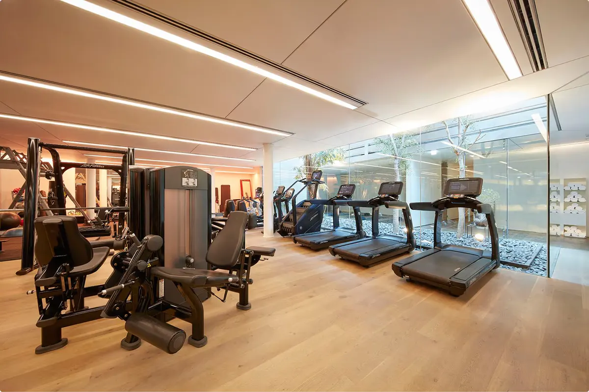 Fitness center with exercise equipment and floor-to-ceiling windows overlooking the city
