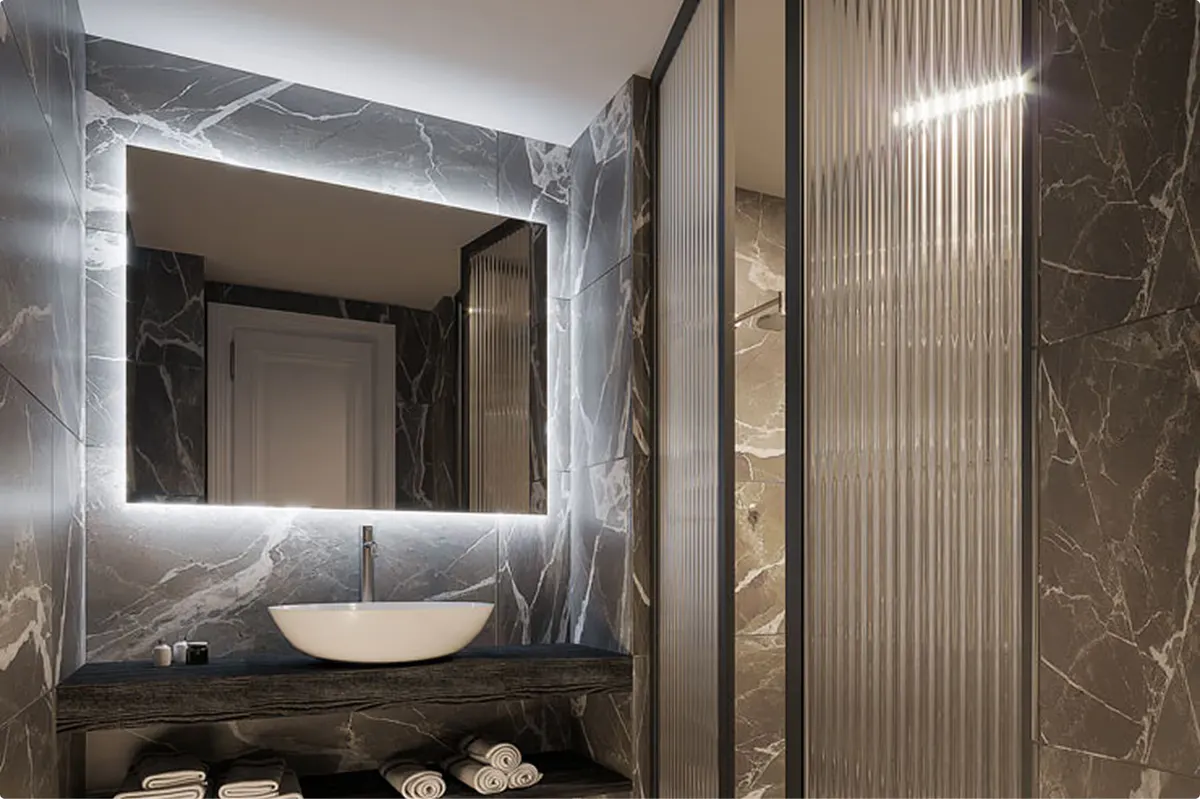 Marble bathroom with black tile accents and sculptural limestone basin