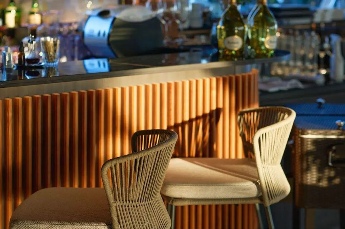 Bar seating with brass railings and glassware in soft lighting