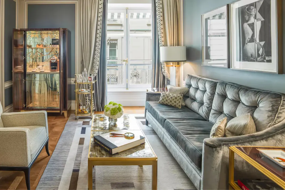 Suite with blue upholstered sofa, tall windows, and classical furnishings