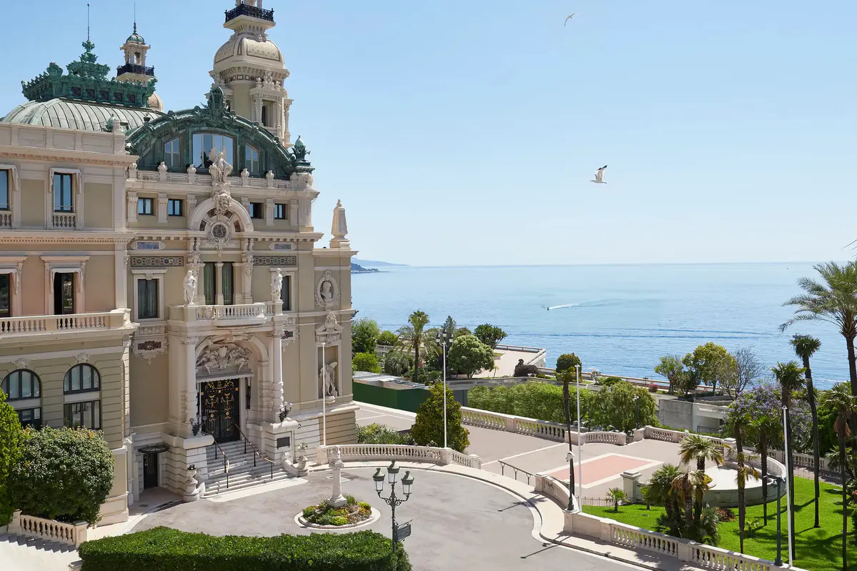Beige palazzo facade with towers overlooking the Mediterranean and palm trees
