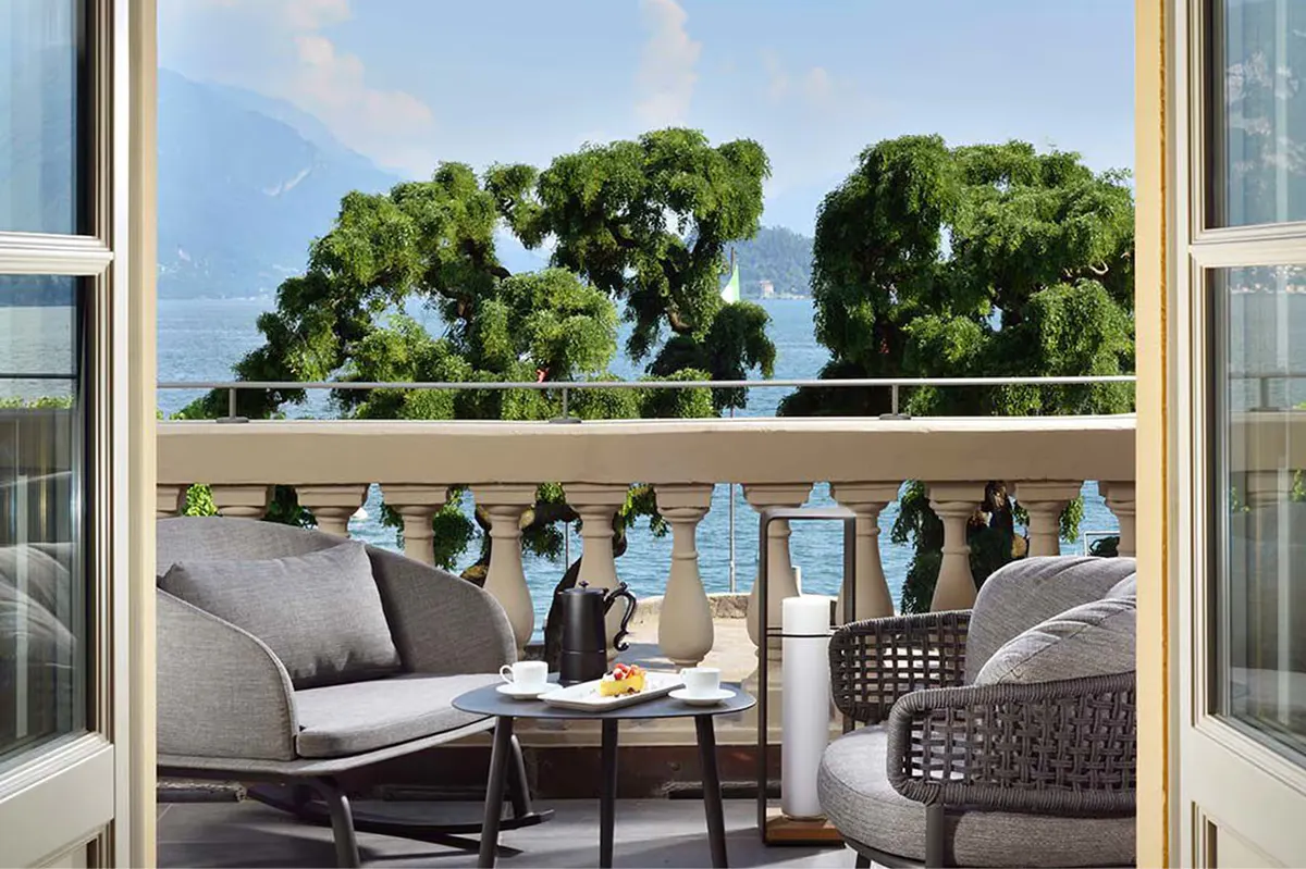 A platform terrace with wicker seating and lake views framed by drapes