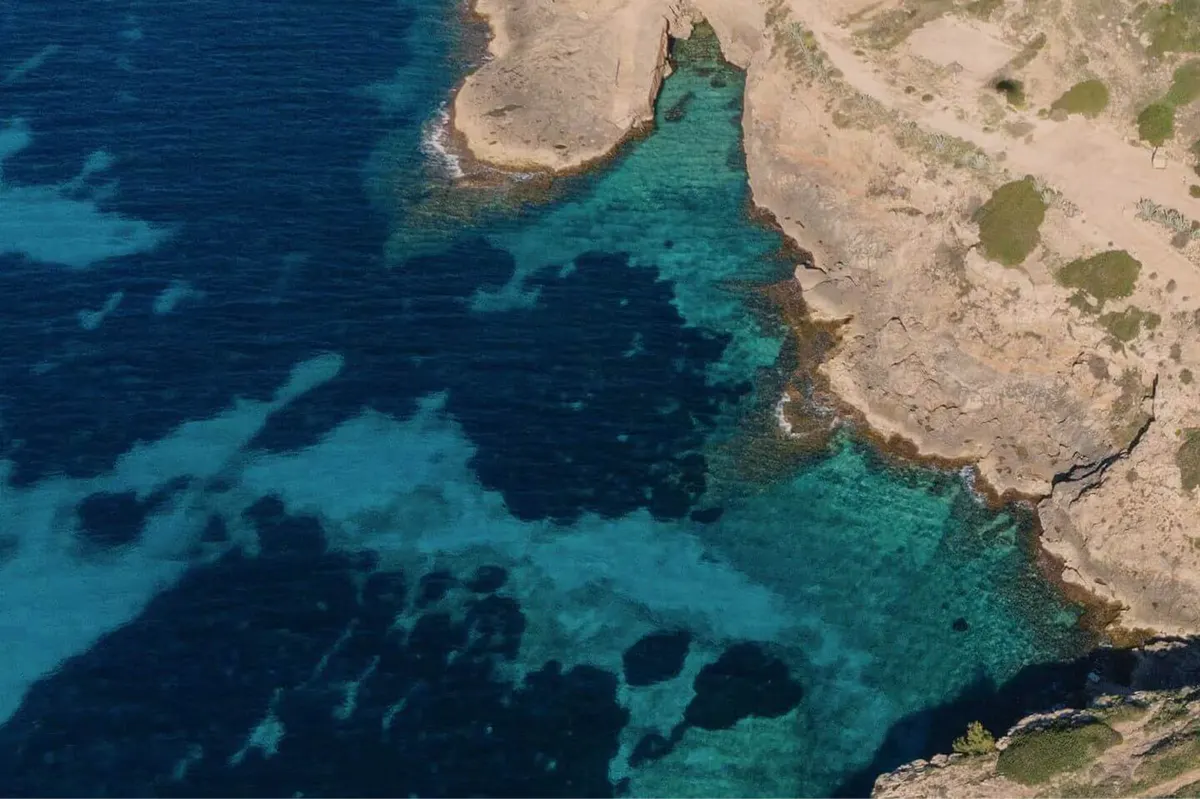 Pale sandy coves and deep turquoise water with rocky outcrops along the Mallorca coast
