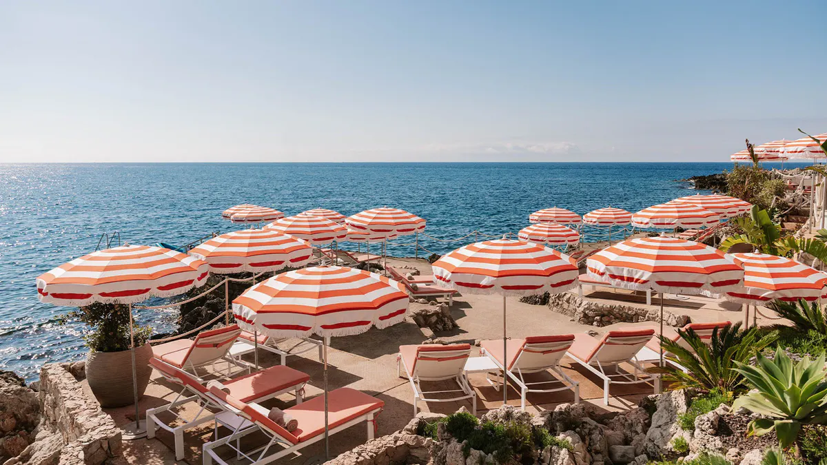 Beach club with striped umbrellas on sand