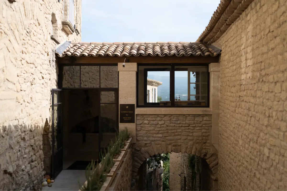 A narrow stone village passageway with restored masonry buildings and small windows