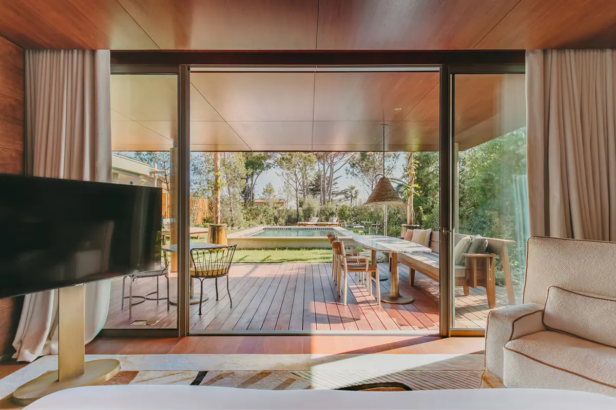 Bedroom with glass doors opening to terrace and landscape vista