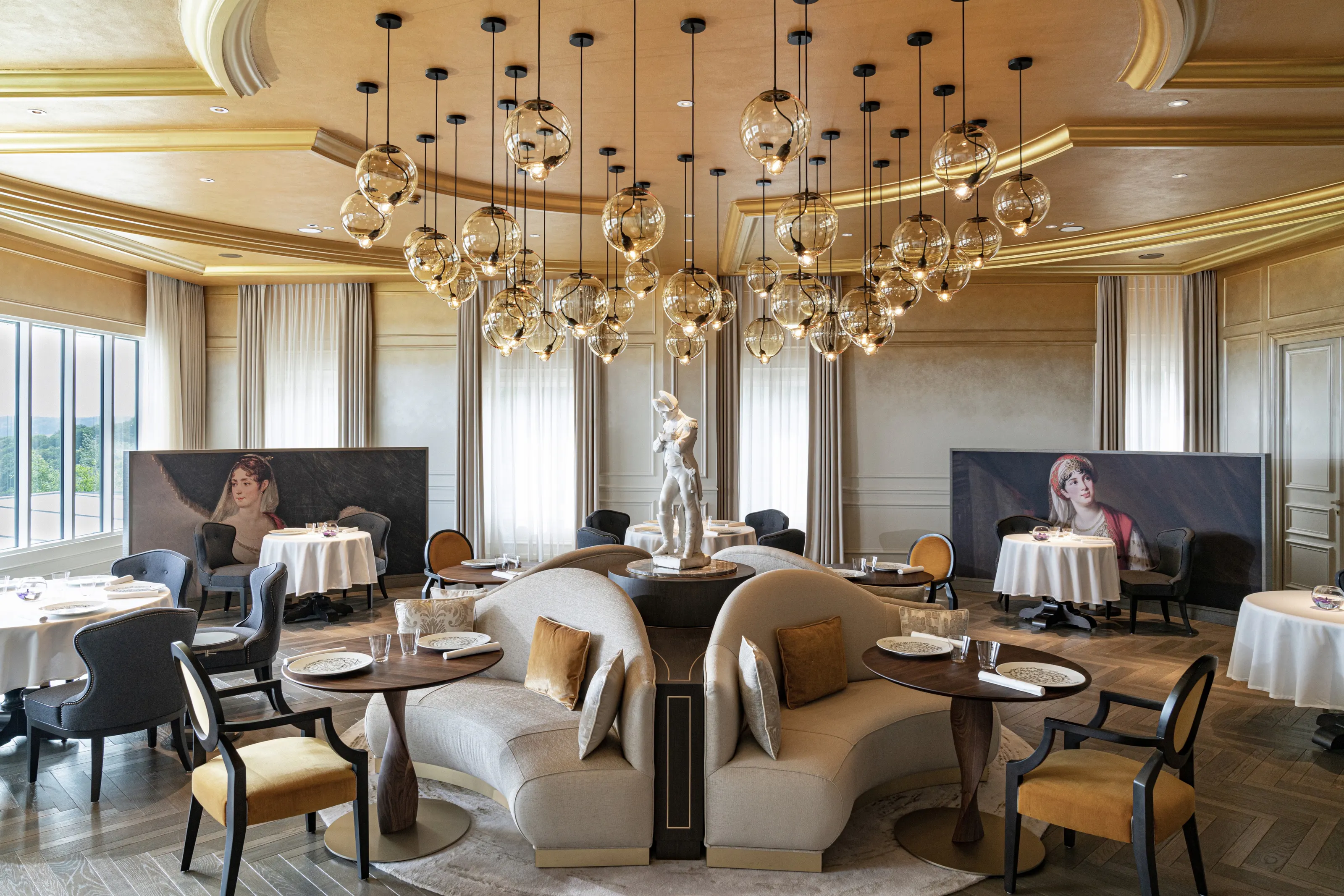 A dining room beneath cascading glass-globe lights in Champagne