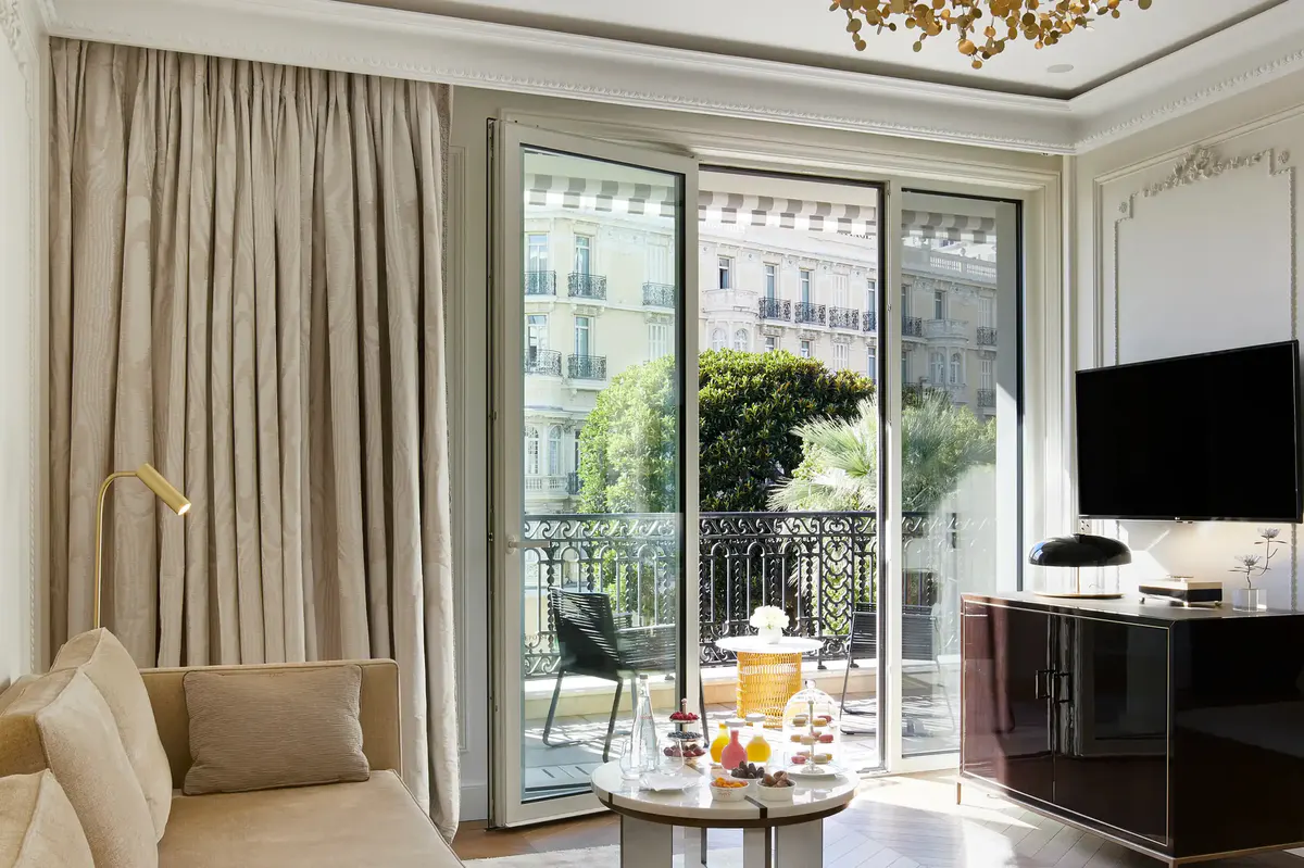 Suite living room with glass doors opening to Monaco balcony and palace views