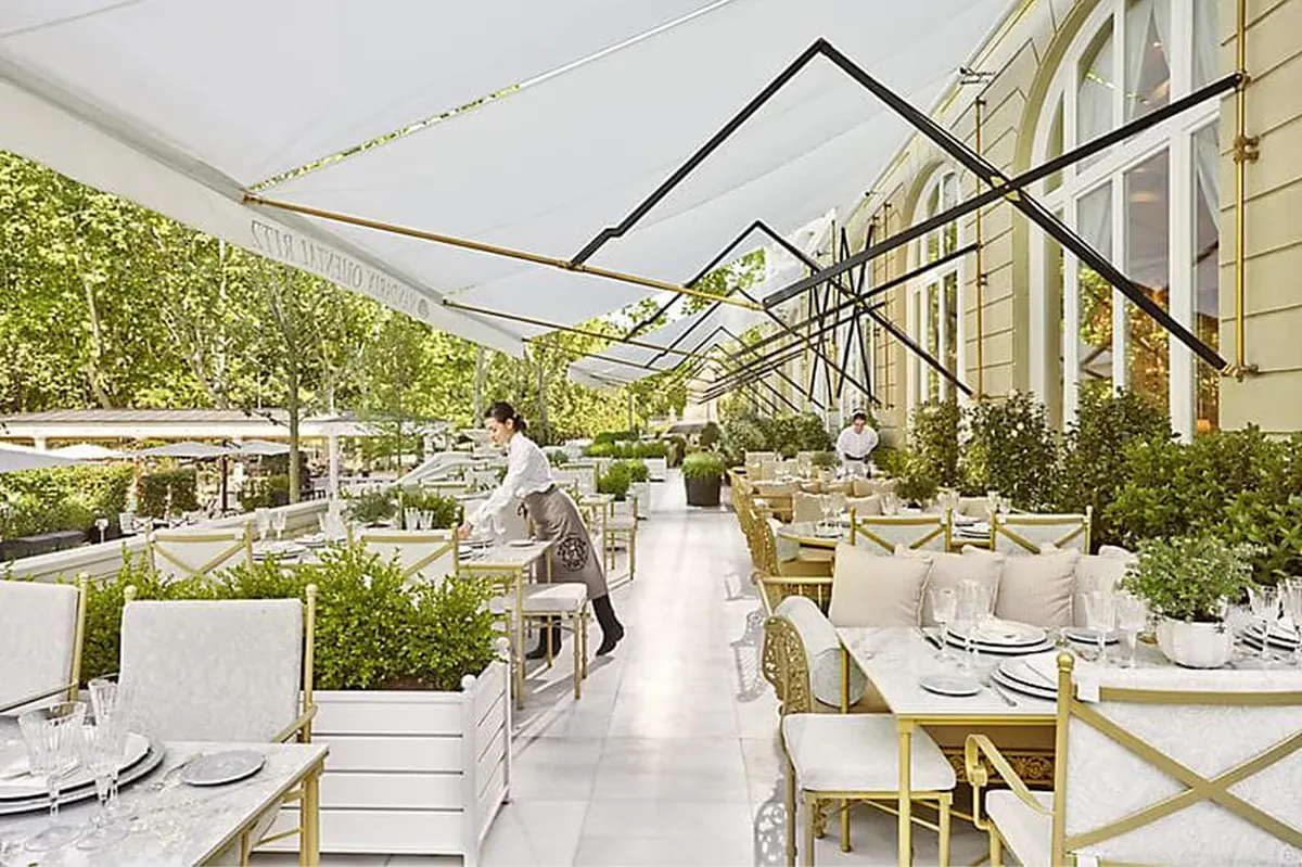 Terrace dining with retractable canopy and garden greenery views