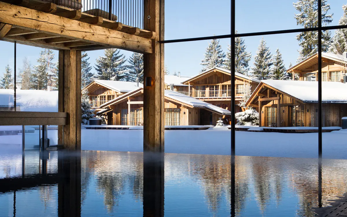Indoor pool viewed through large windows with property reflected