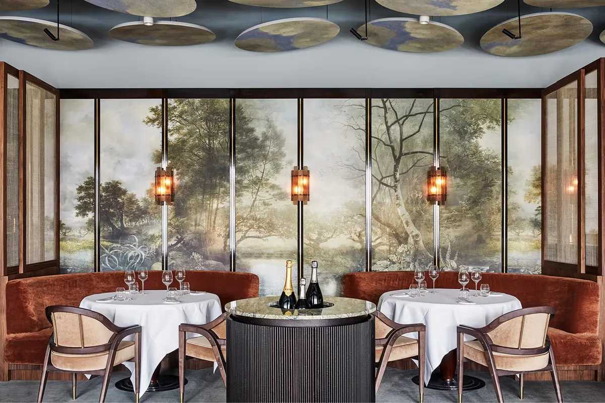 Dining room with glass wine display, terracotta walls, and brass fixtures