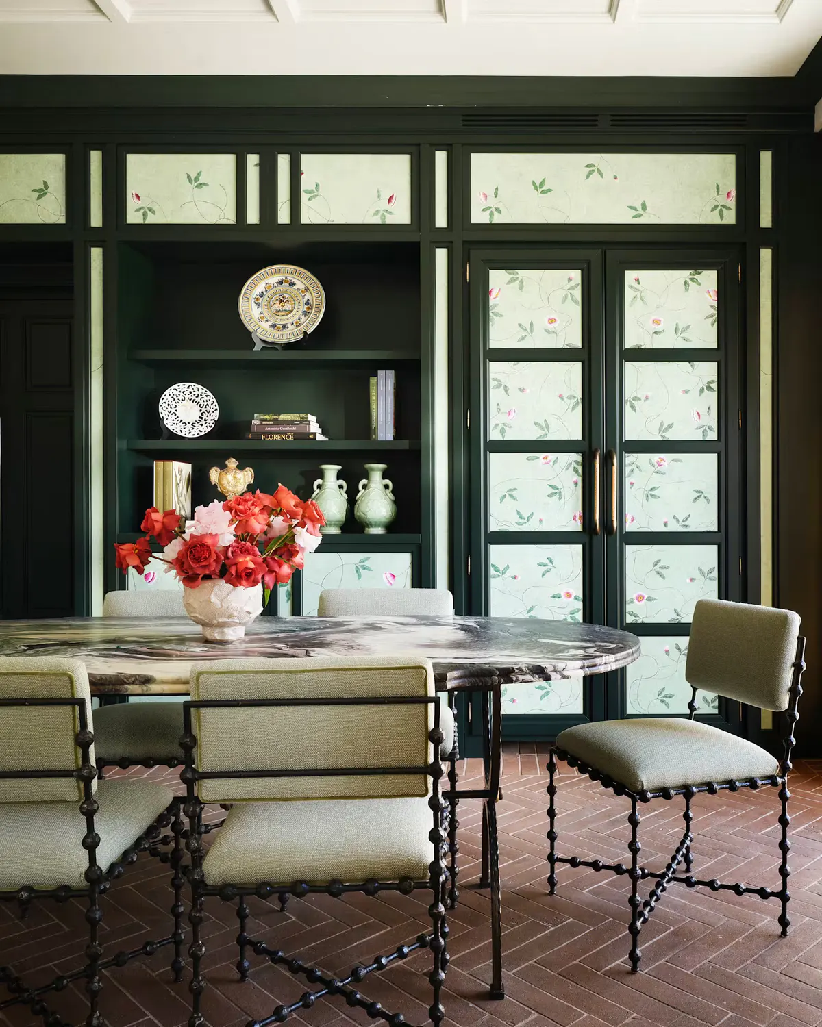 The dining room of the Botanica suite, panelled in deep green with hand-painted floral panes