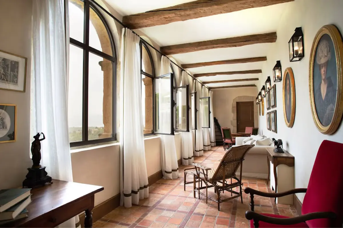 Gallery with exposed beams, pale walls, and multiple dark wood doors
