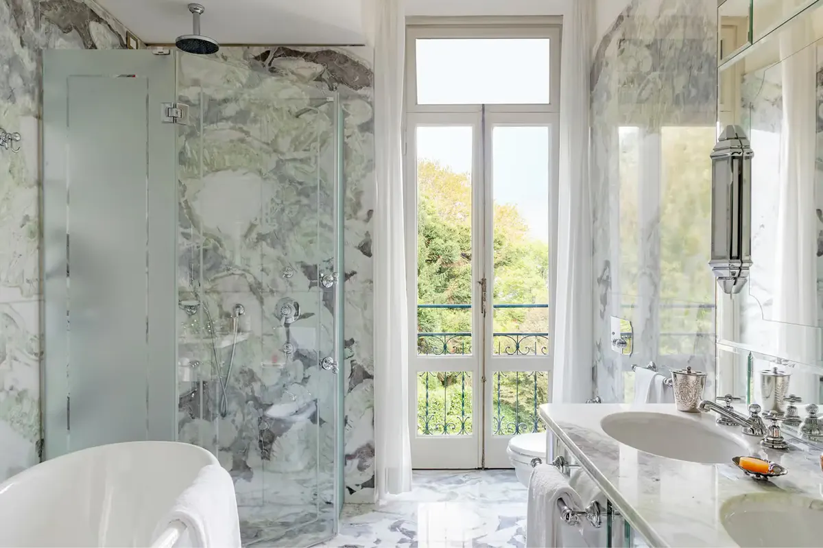 Marble bathroom with glass shower enclosure and lake-view doors