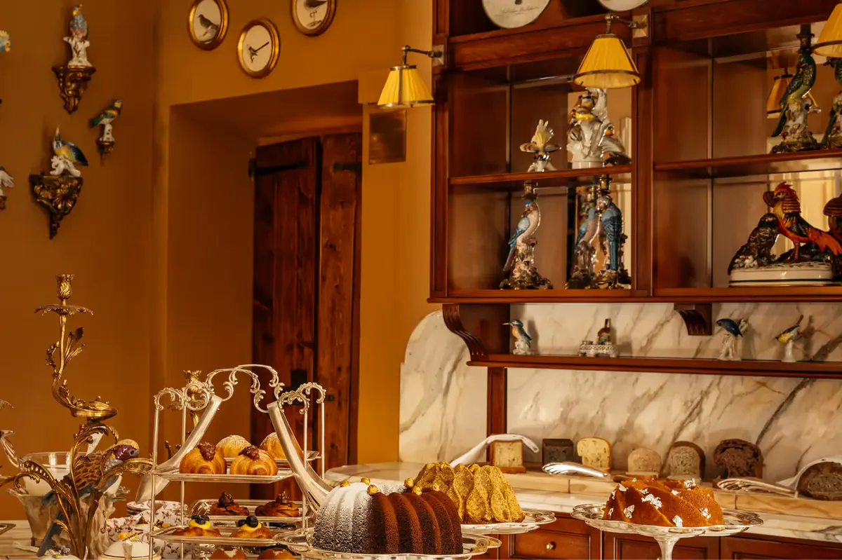 A formal dining room display with ornate shelving, candleabra, and fine ceramics