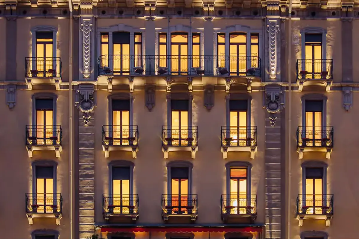 Hotel facade at night with lit windows in symmetrical rows