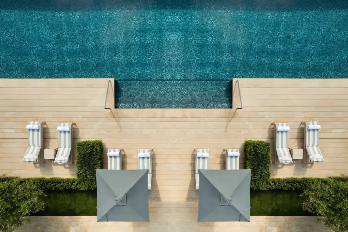 Pool deck with lounge chairs and turquoise water viewed from above