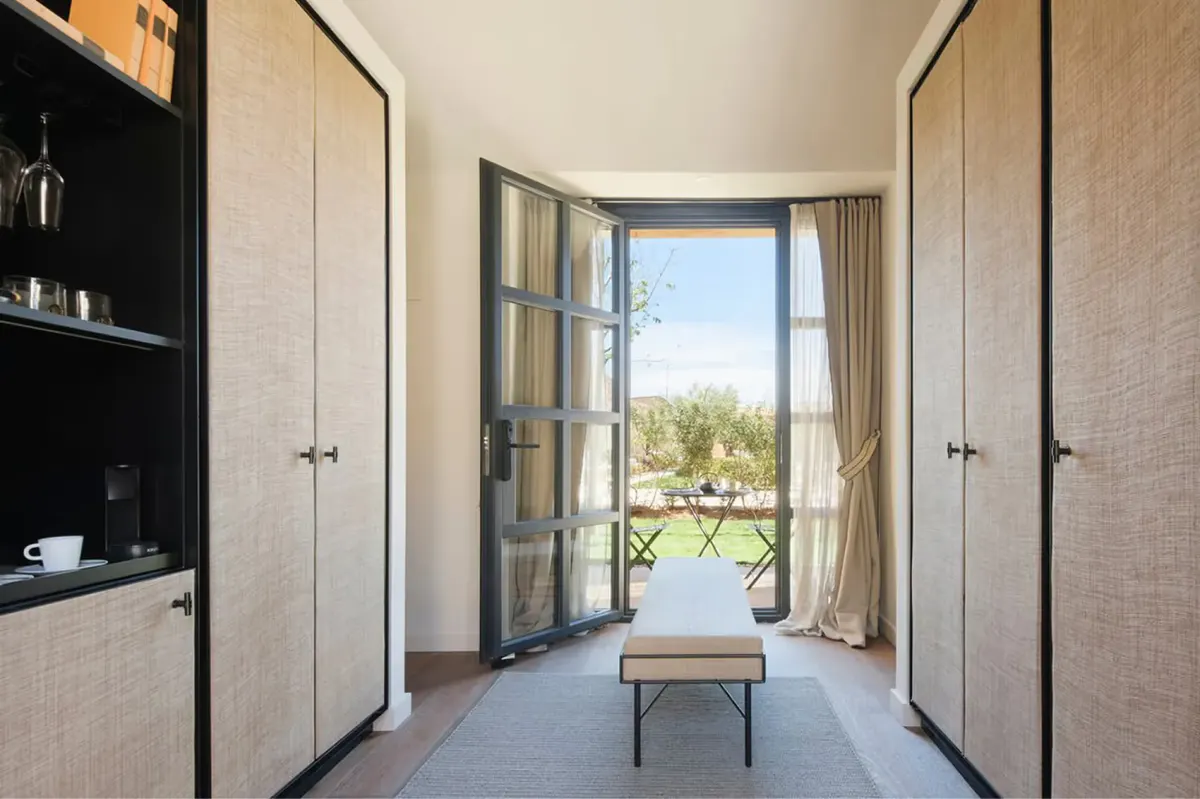 Suite with four-poster canopy bed and modern furnishings in soft colors