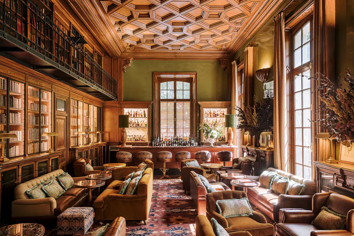 Lounge corner with marble-topped table, bronze sculptural base, and wood armchairs