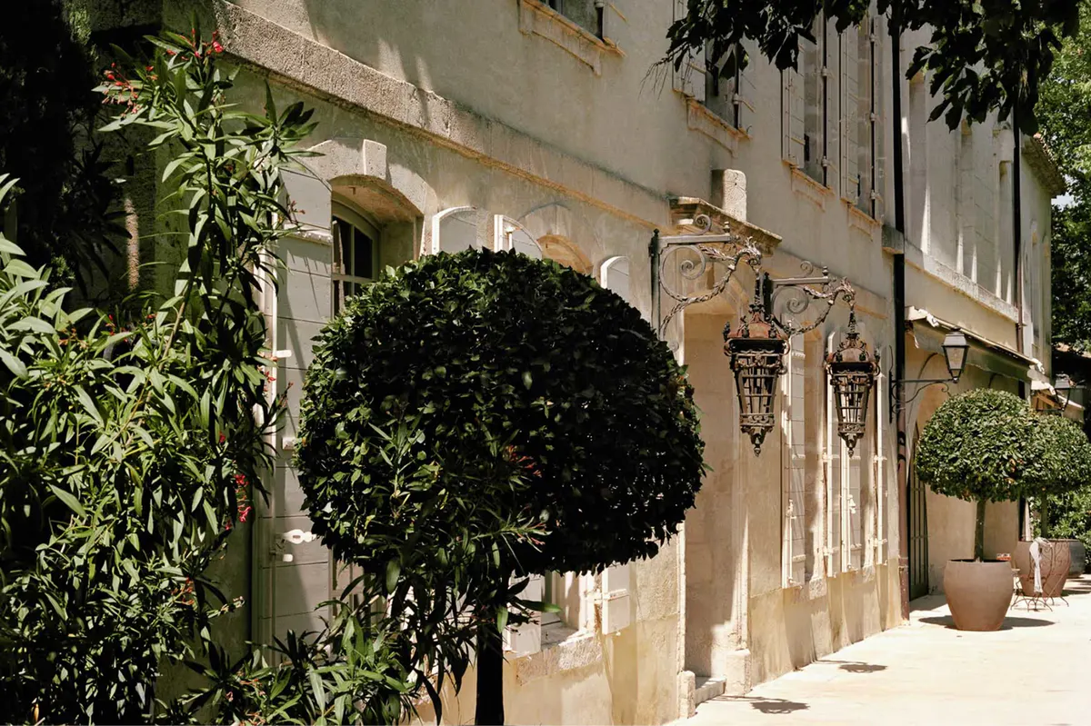 Sheltered courtyard entrance with potted bay topiaries and stone archways