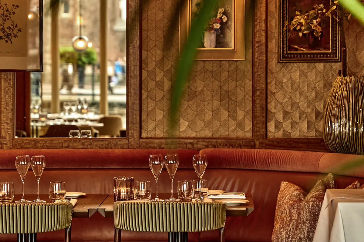 Lounge bar with decorative mirrors, wood-paneled walls, and curated antique furnishings