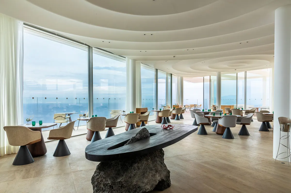 Dining venue with floor-to-ceiling windows and coastal vistas