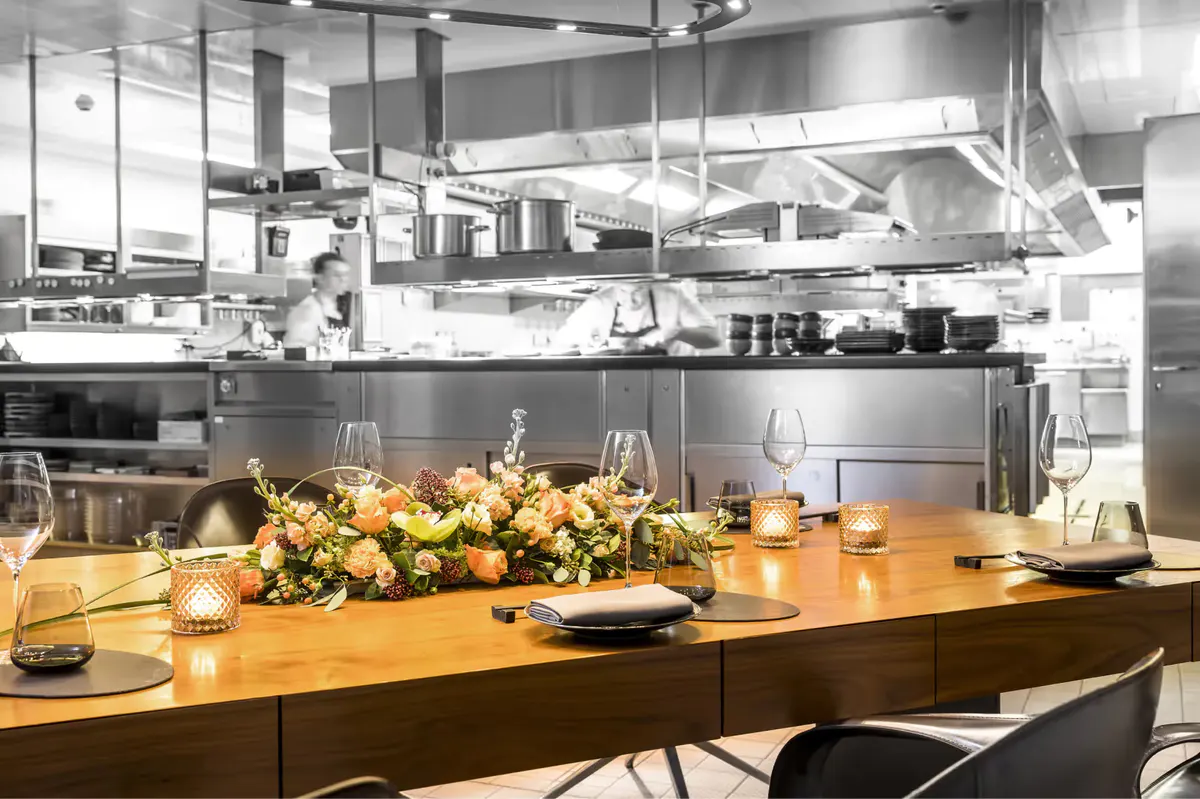 Open kitchen counter with chef’s view and fresh flower arrangement