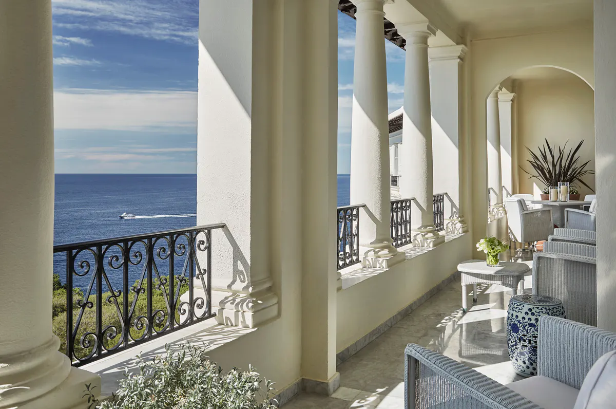 Bedroom with arched passage and classical columns framing sea views