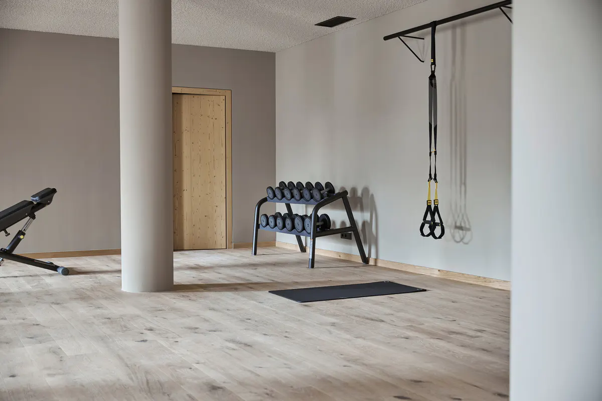 A fitness studio with exercise equipment, wood finishes, and natural light from clerestory windows
