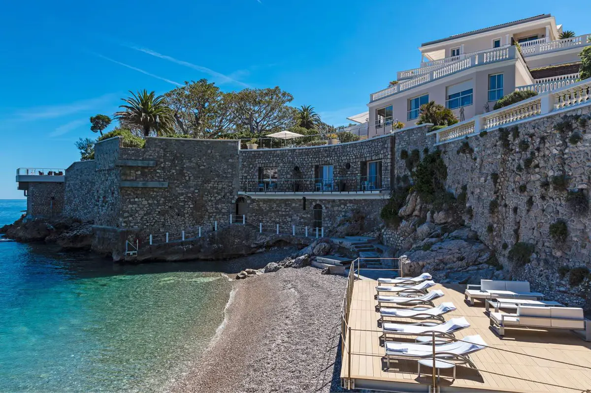 Stone structures and loungers on a private beach cove