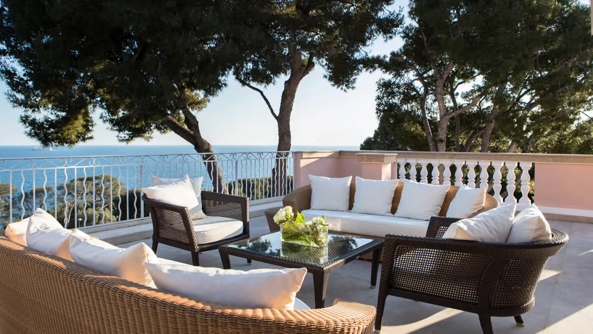 Clifftop terrace with rattan seating and sea horizon beyond