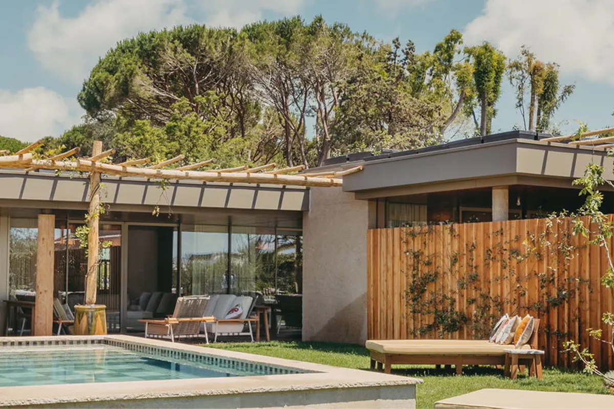 Modern villa with wood siding and private pool among mature landscape