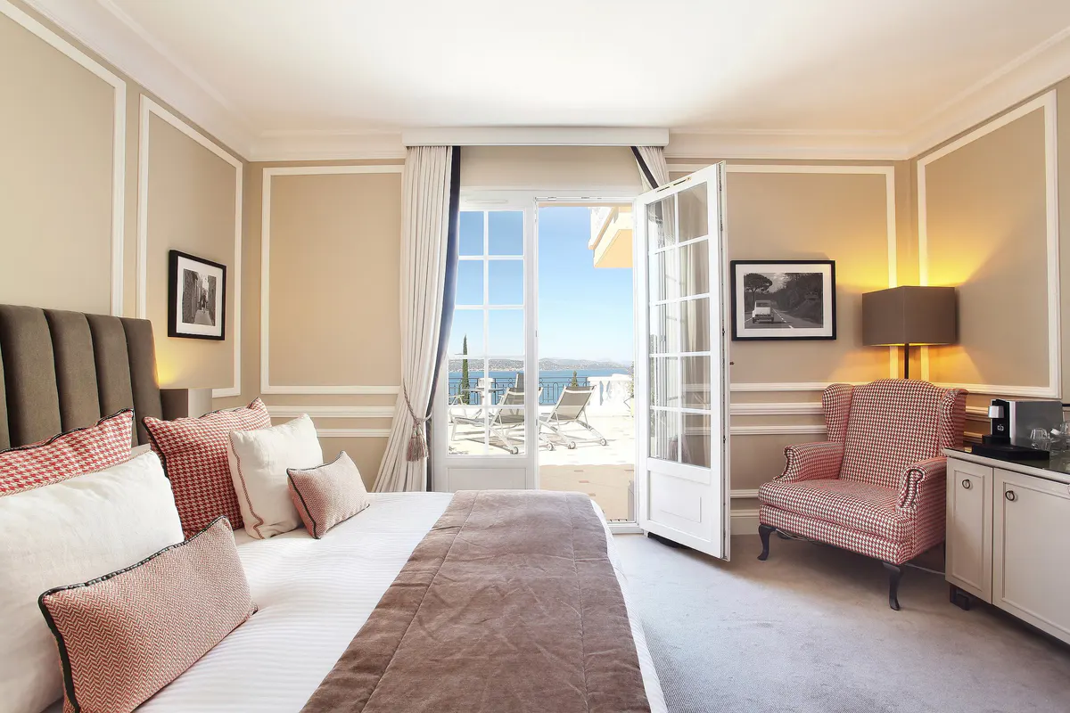 Suite with upholstered reading chair beside floor-to-ceiling windows