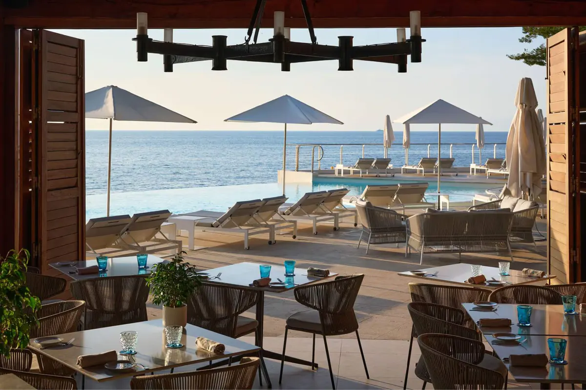 Indoor dining room with wooden doors open to beachside lounging
