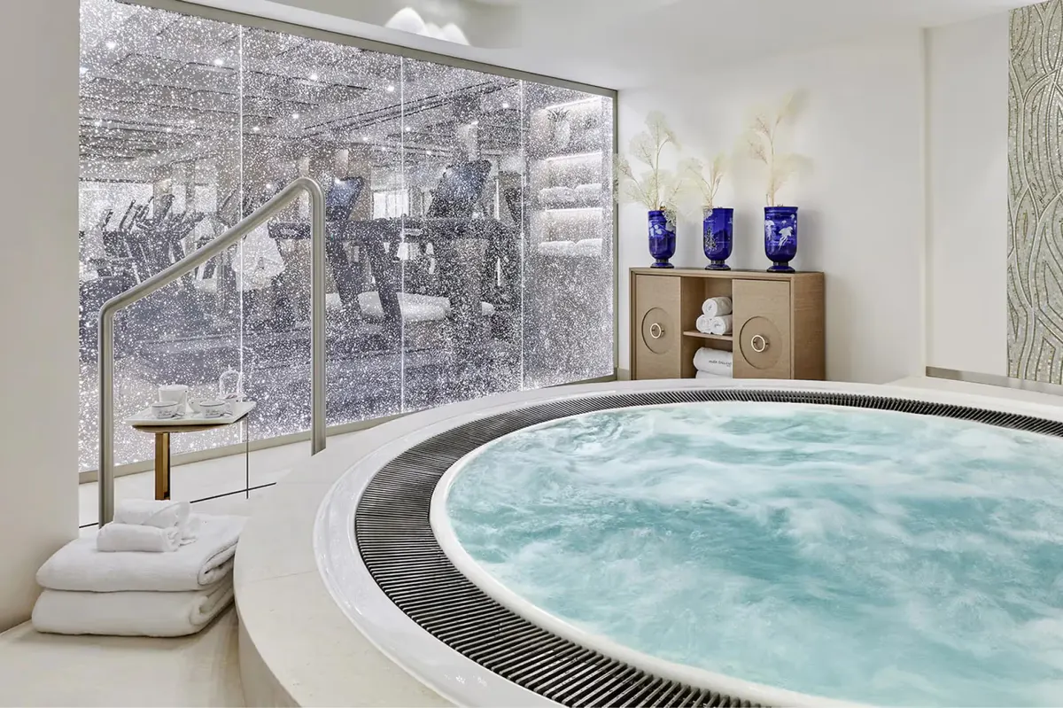 Spa tub with turquoise water and large window overlooking grounds