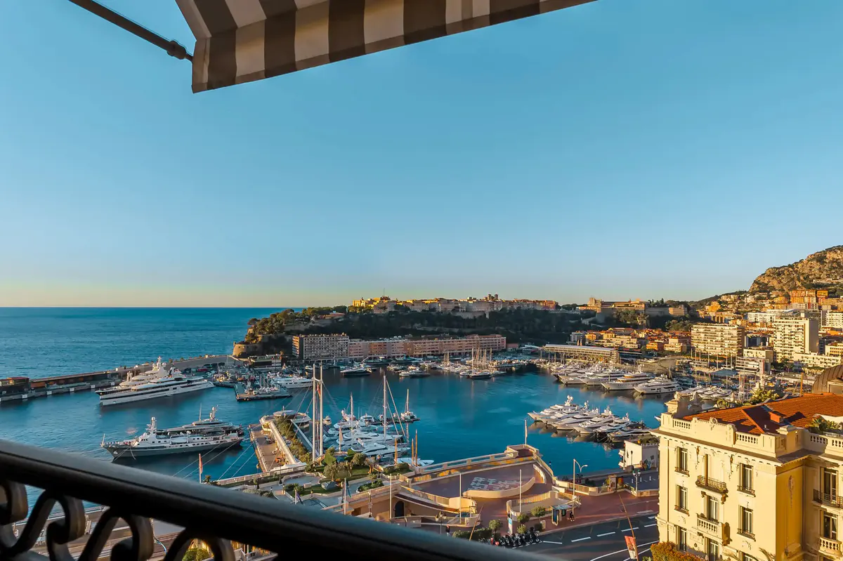 View from balcony toward harbor with boats and yachts, Mediterranean in distance