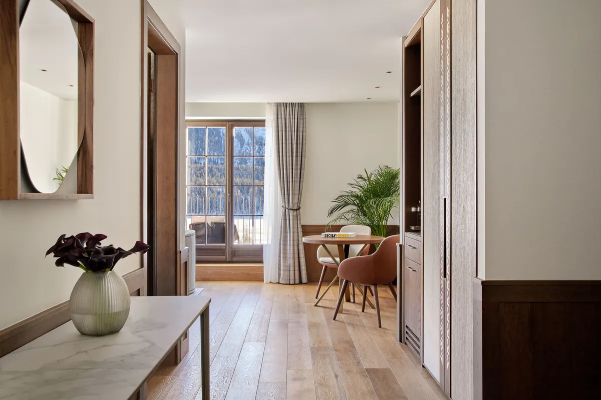 Hallway with white walls, mirror, wood details, and mountain views through open doors