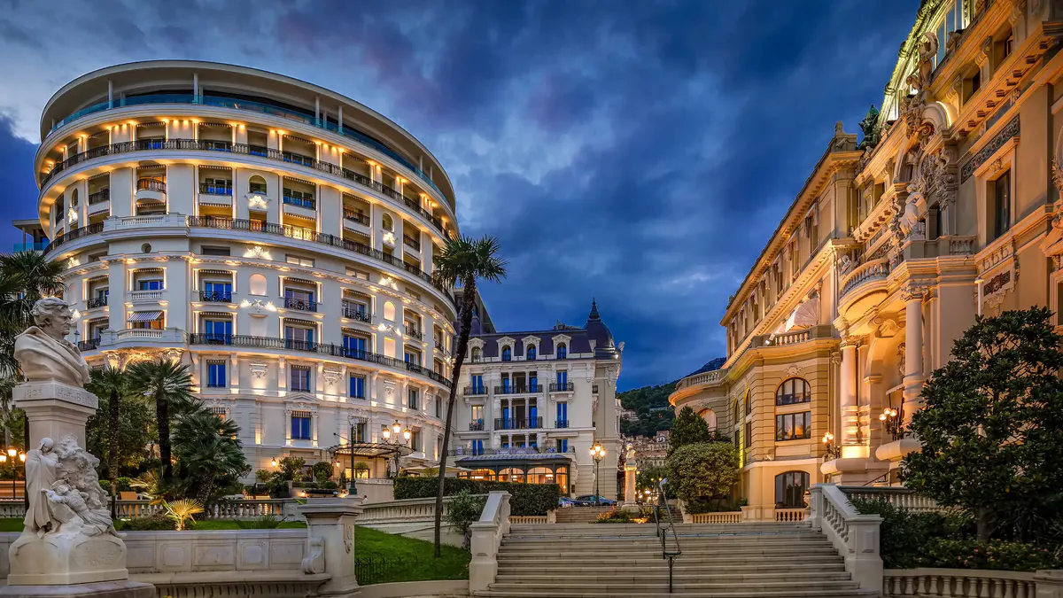 Place du Casino at dusk with lit palazzo and surrounding buildings